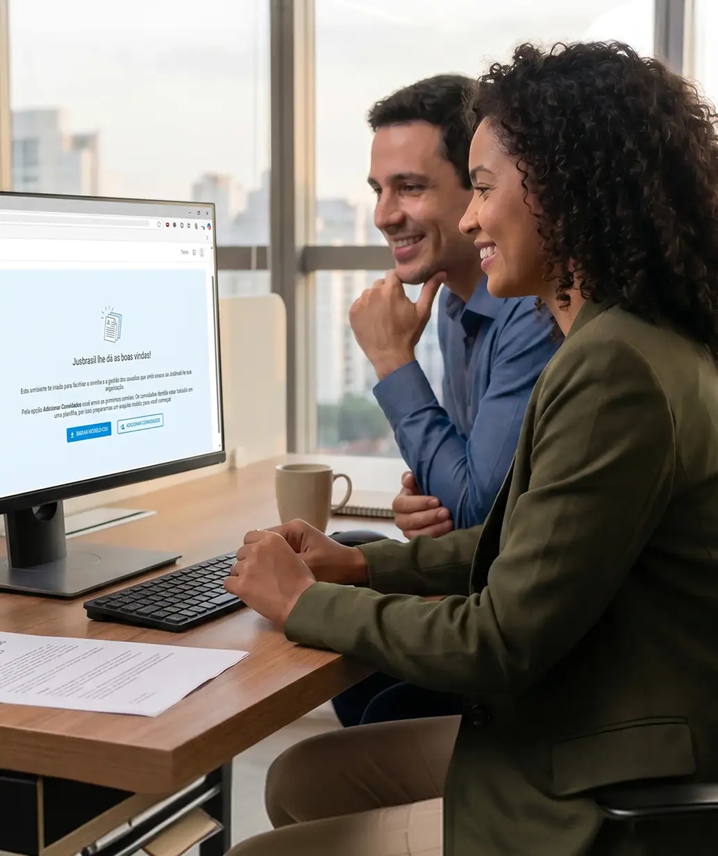 Servidora pública sorrindo enquanto trabalha no notebook em um gabinete